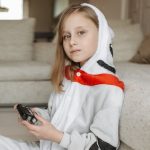 Girl in a onesie holding a glucometer (Photo: Pavel Danilyuk)