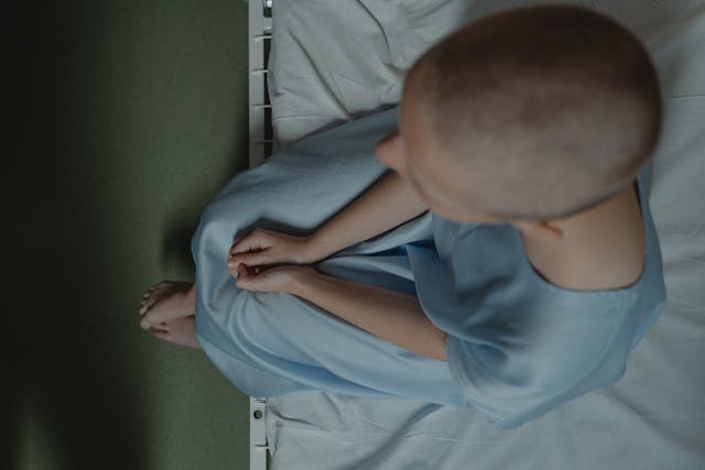 A cancer patient sitting on a hospital bed, viewed from above (Photo: Tima Miroshnichenko)